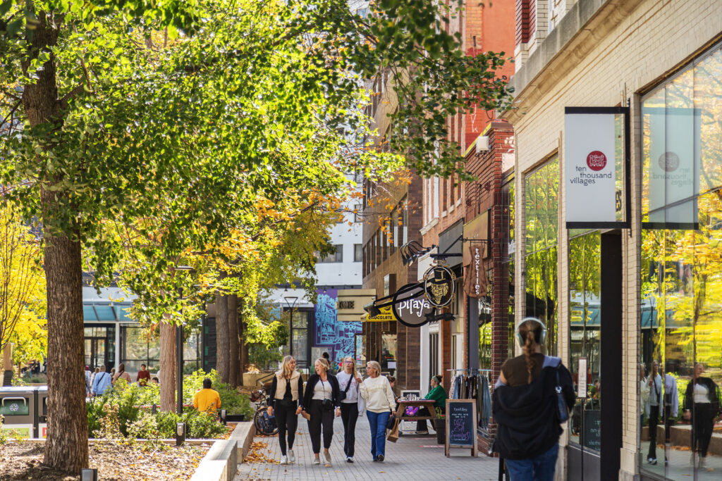 Shoppers walking on the sidewalks of downtown Iowa City businesses in the fall season.